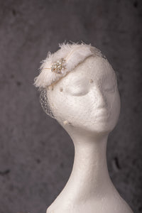White feather and diamante headpiece with birdcage .