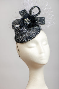 Dark navy and white headpiece with waffle veiling.