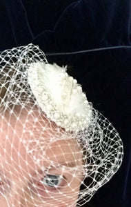 Satin pearl and feather bridal headpiece with birdcage.