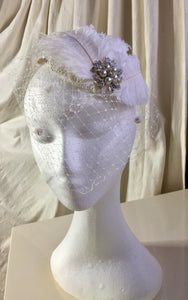 White feather and diamante headpiece with birdcage .